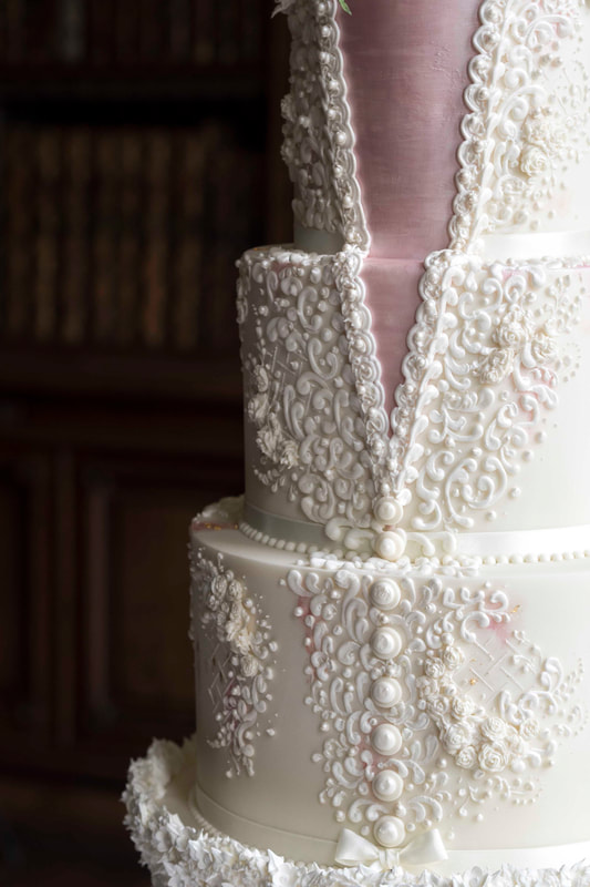 Elaborate and elegant wedding cake with detail to match the bride's dress.